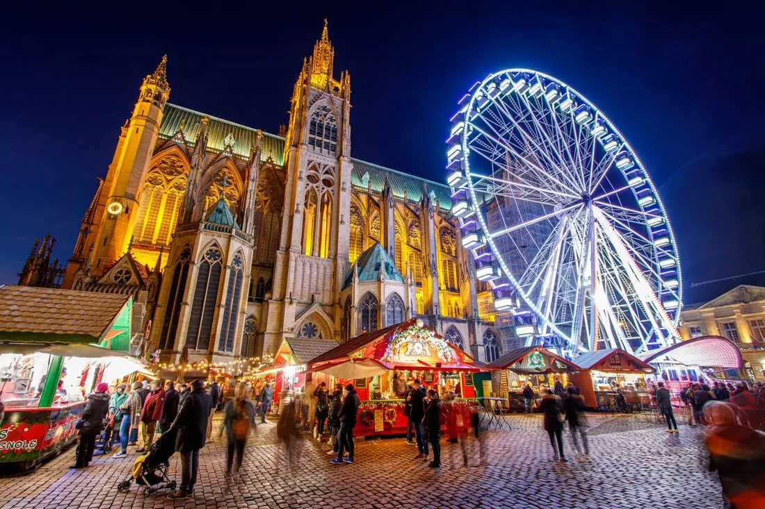 Marché de Noël place d'Armes à Metz, la nuit, avec la grande roue et la cathédrale illuminée